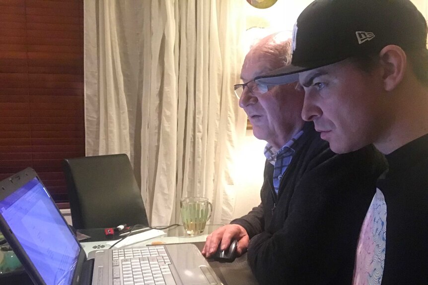 Two men looking at a computer screen searching for results.