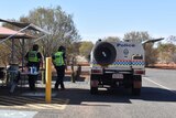 Uniformed police at the Kulgera Border Control Point, in Central Australia. The sky is blue.