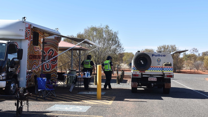 Uniformed police at the Kulgera Border Control Point, in Central Australia. The sky is blue.