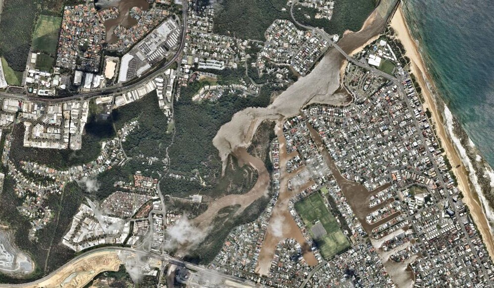 The Gold Coast from above" canals and rivers turned brown, The rowed houses of Palm Beach through a clear sky. 