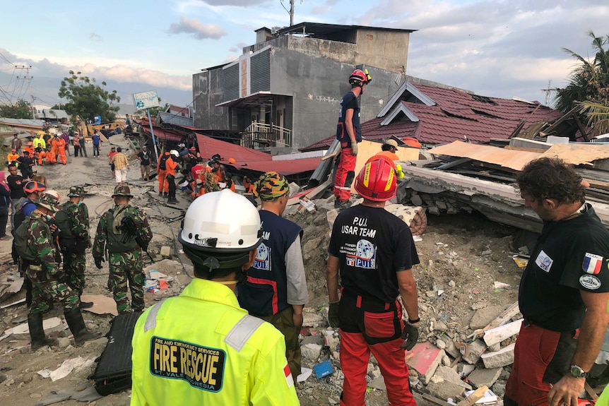 A French search team investigates reports of knocking from under rubble at Balaroa.