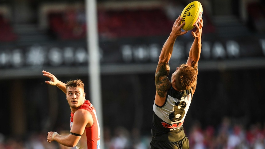 Port Adelaide's Hamish Hartlett (R) marks against the Sydney Swans at the SCG on April 1, 2018.  