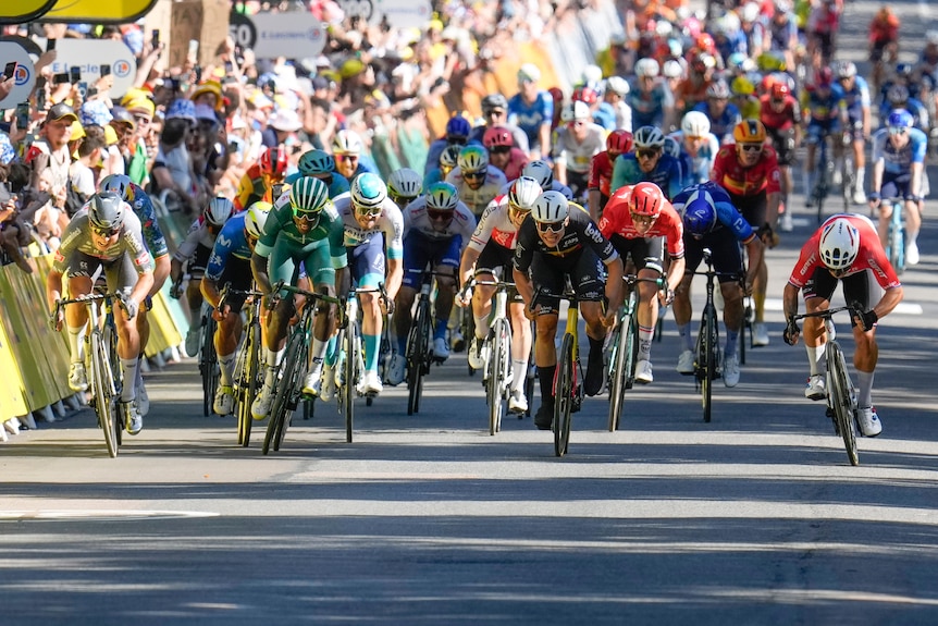A sprint finish at the Tour de France, with cyclists across the road, the rider on the far right will be the winner.