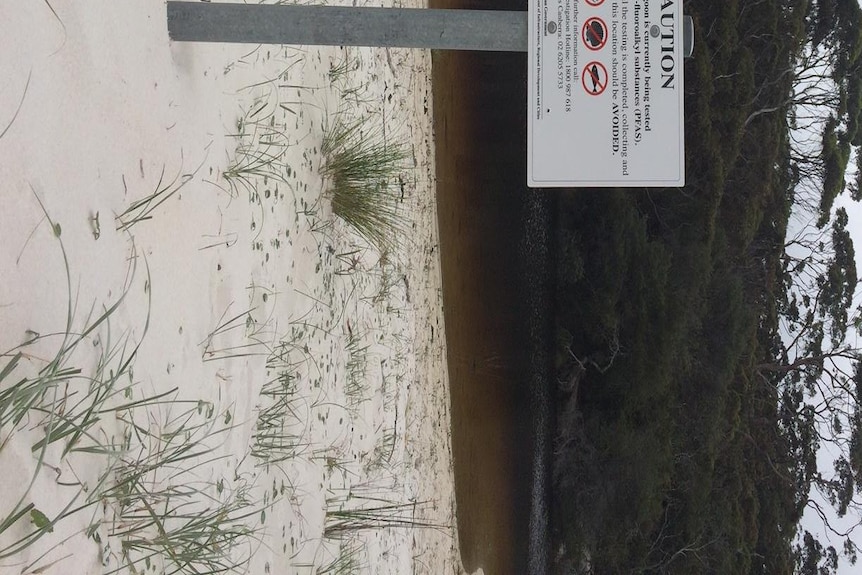A warning sign in front of a creek