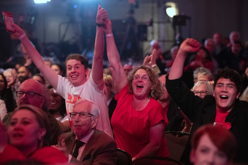 A group of people in a crowd cheering