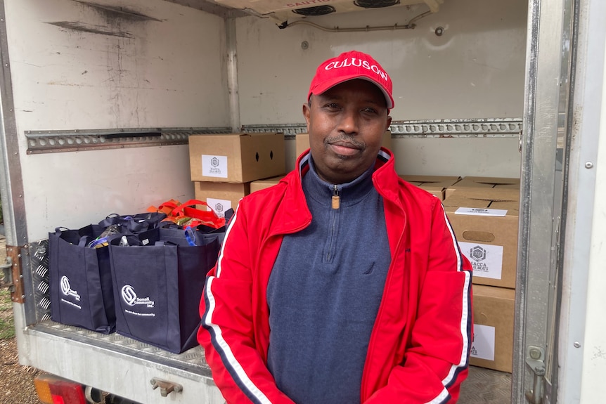 Man standing behind a truck with food deliveries