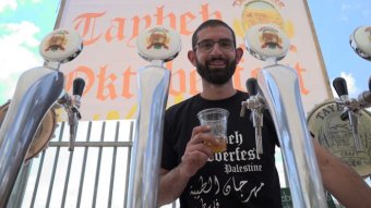 Palestinian brewer Canaan Khoury with beer taps and a glass of beer.