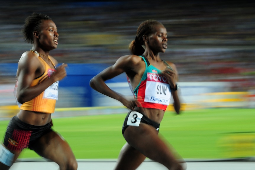 Two runners mid-race with the background blurred.