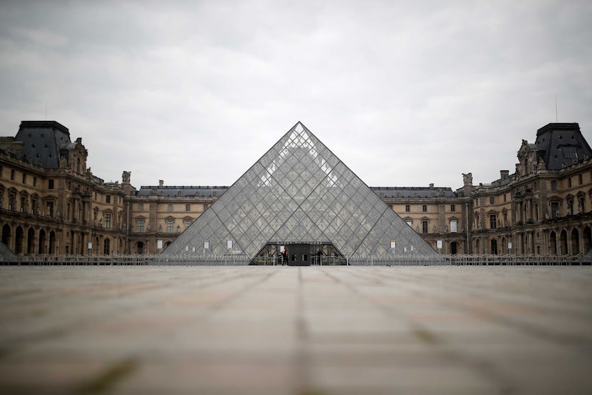 The space in front of the glass Pyramid of the Louvre museum is empty.