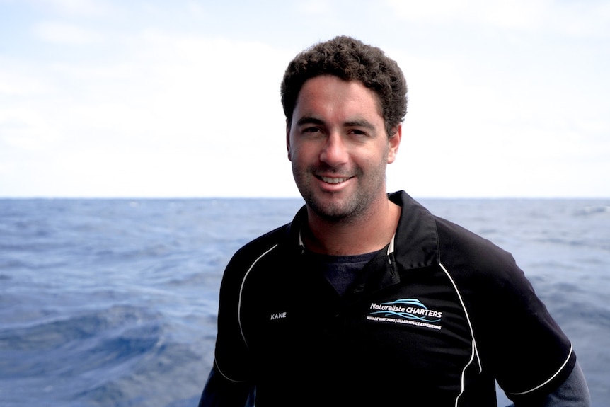 A young man faces camera on a boat