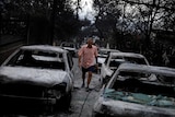 A man walks among burnt cars in Mati.