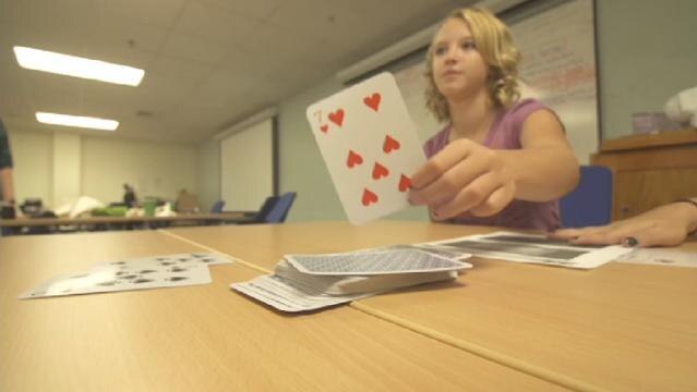 Girl places cards from deck onto table