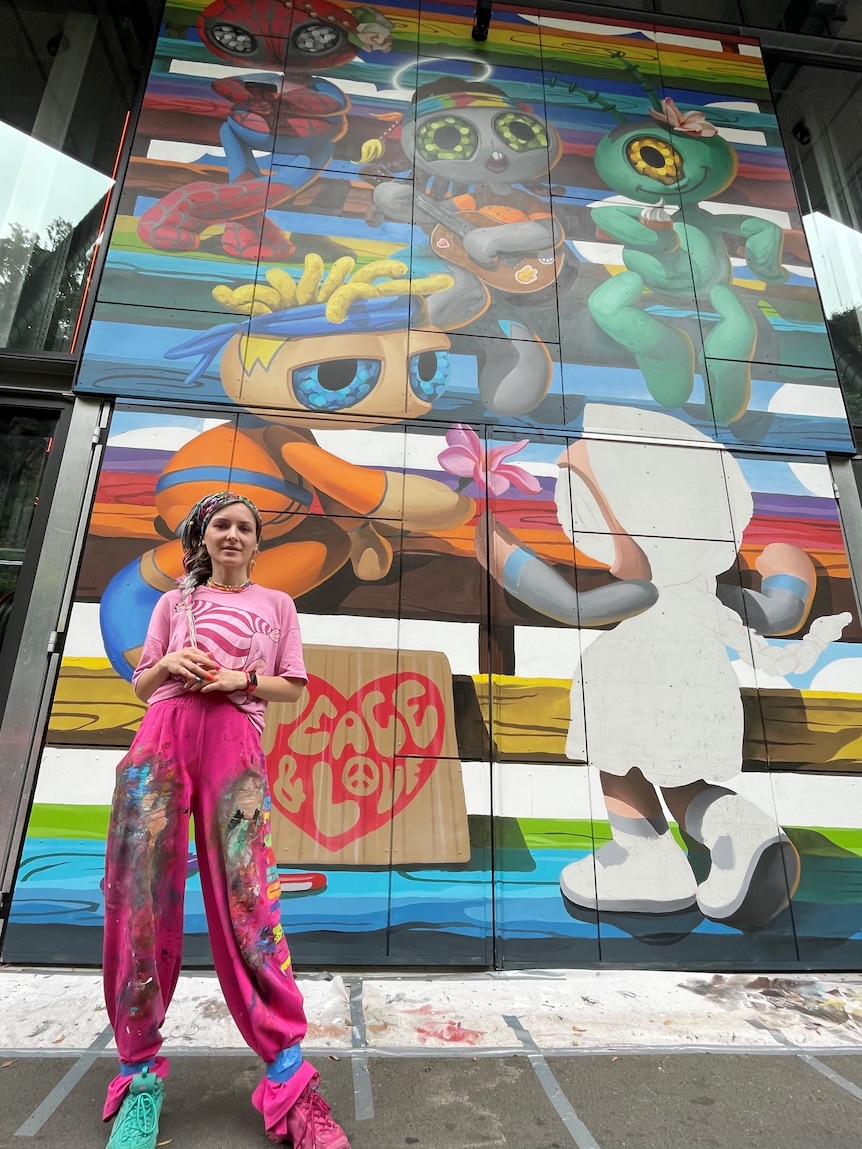 Viktoria Veisbrut standing infront of the complete mural.