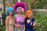 Amy and her housemates dressed in loud and glitter outfits with bright wigs, in story about lockdown birthdays..