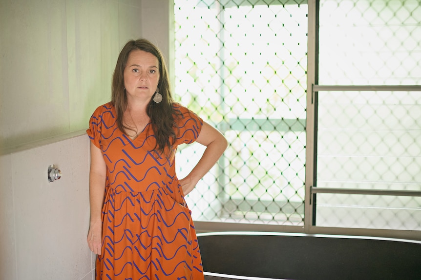 Sue Phoo stands in her bathroom and looks at the camera.