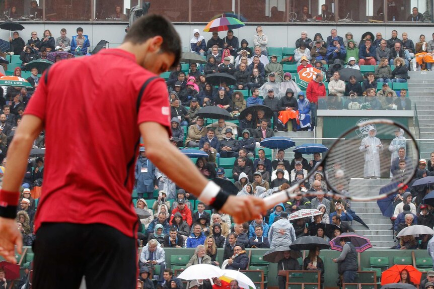 Novak Djokovic looks on as the rain comes again at French Open