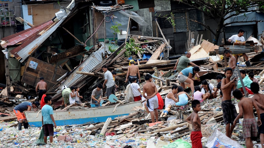 Residents salvage housing materials from a Manila Bay community that was destroyed by storm surges unleashed by Typhoon Nesat