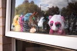 A line of teddy bears in a window.