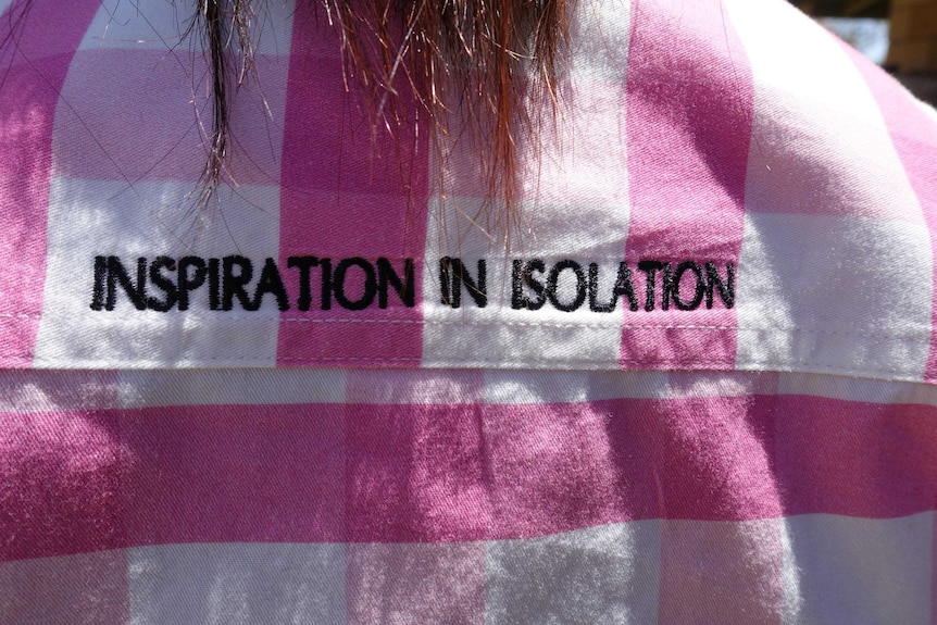 A woman wearing an 'inspiration in isolation' shirt