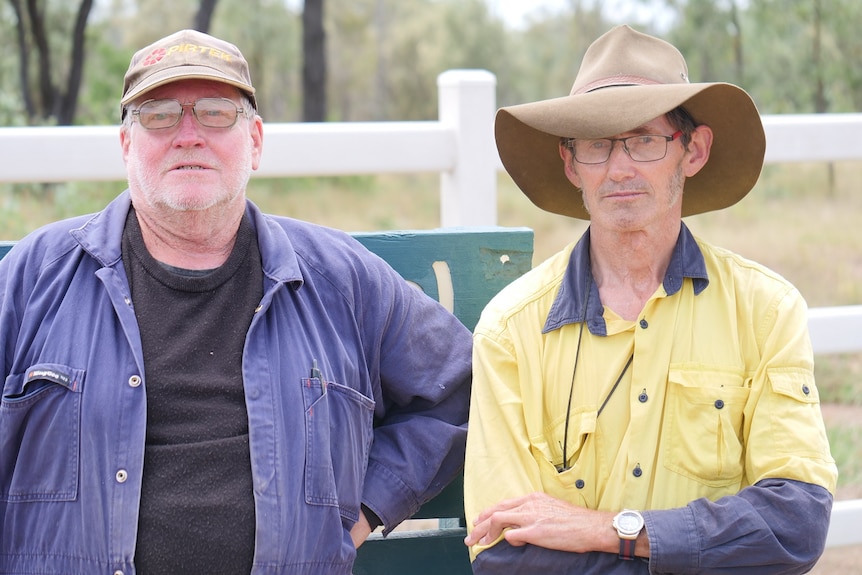 Trevor Naughton and Alexander Dudley stand at a national park sign and stare seriously into the camera.