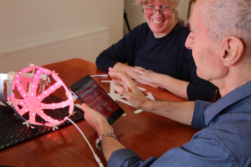 A man uses an app on a mobile device to change the light frequency of a bucket helmet