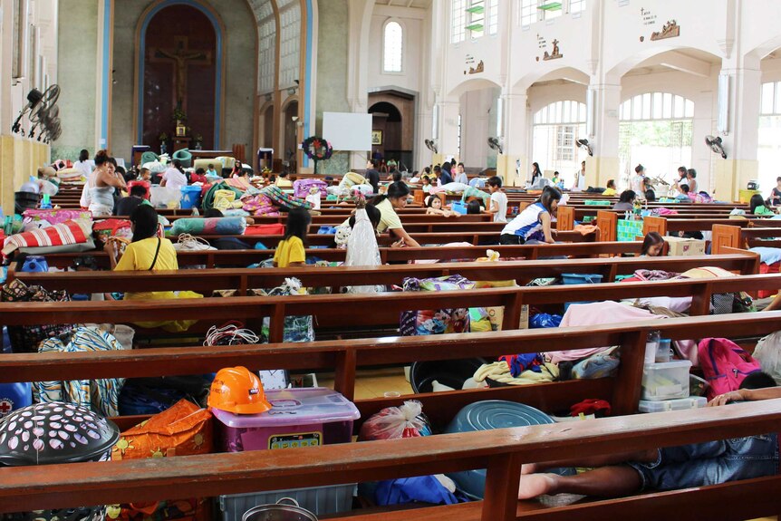 Tacloban residents take shelter inside a church after evacuating their homes ahead of Super Typhoon Hagupit's arrival