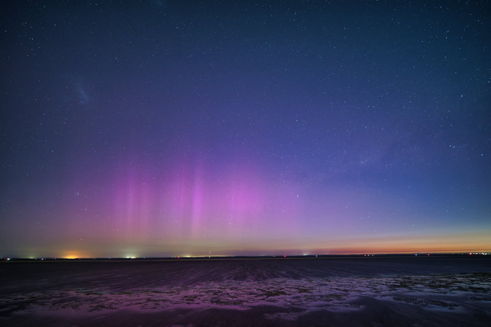 Um céu roxo e azul escuro com uma onda quebrando