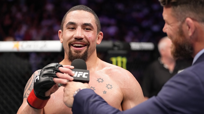 UFC fighter Robert Whittaker speaks into the UFC microphone after a fight.