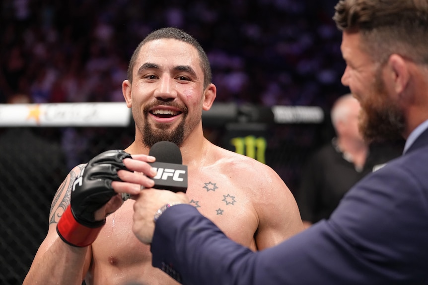 UFC fighter Robert Whittaker speaks into the UFC microphone after a fight.