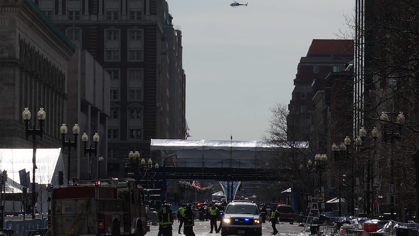 Helicopters fly overhead as emergency crews continue working in Boston.