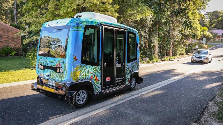 The BusBot vehicle in front of a sedan.