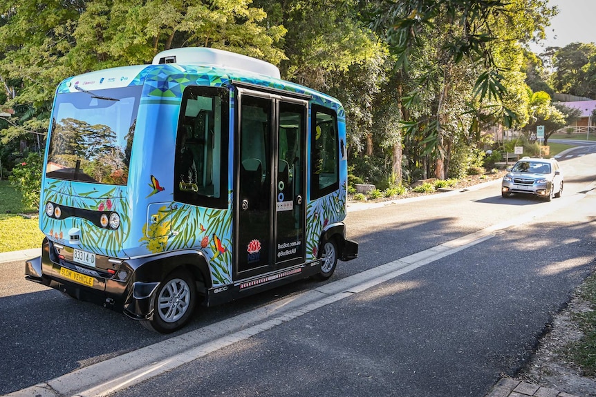 The BusBot vehicle in front of a sedan.