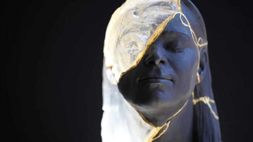 Close-up of a sculpture of a young woman's face created by kintsugi