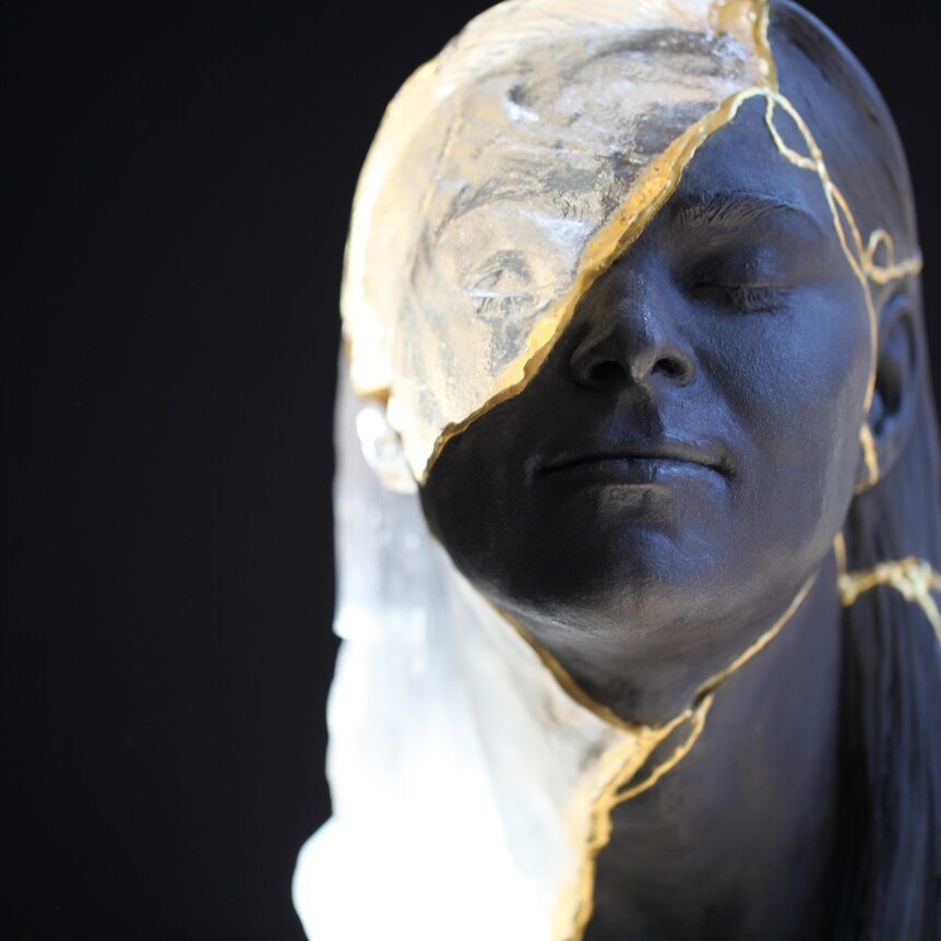 Close-up of a sculpture of a young woman's face created by kintsugi