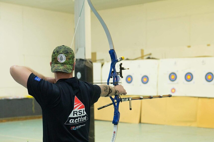 Stewart Sherman fires an arrow at a target.