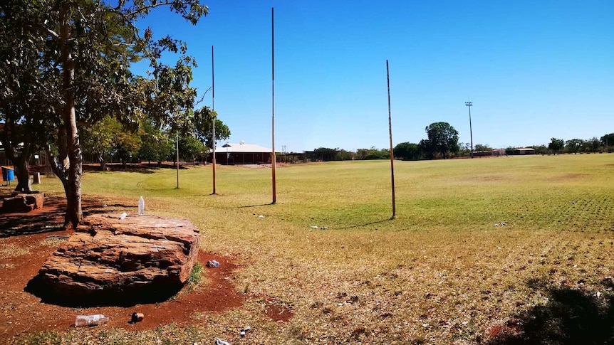 An outback football oval beneath a sunny sky.