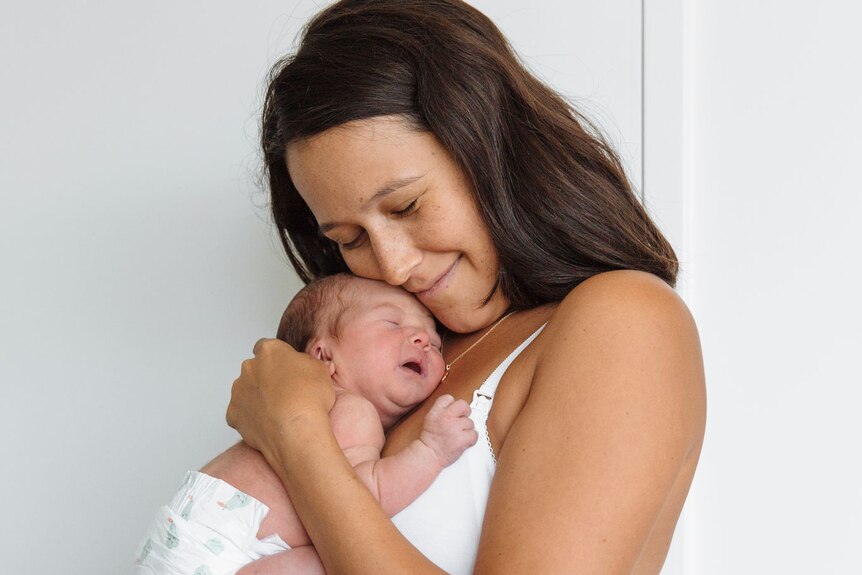 Sophie Pearce hugs her newborn baby.