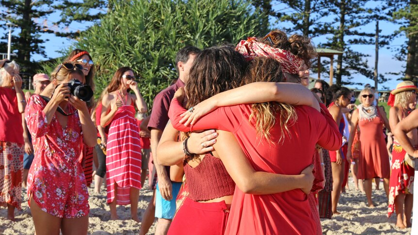 Women embrace at One Billion Rising celebrations on Byron Bay's Main Beach