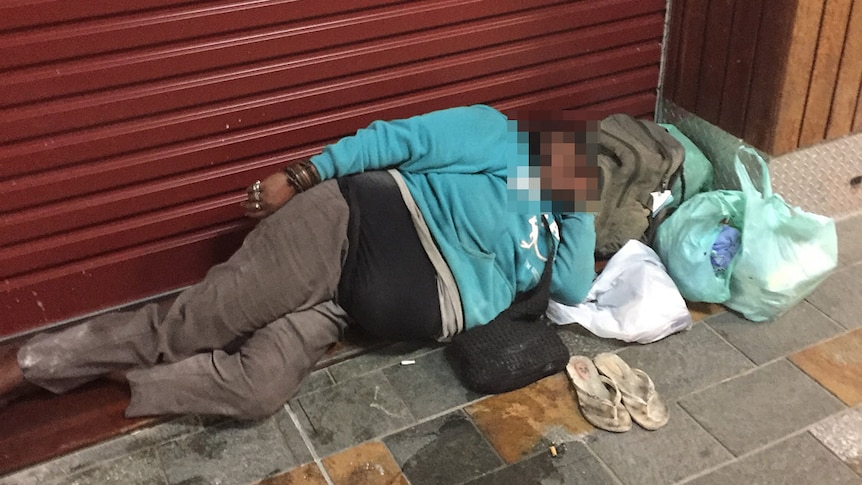 Homeless woman lies in street in Cairns CBD