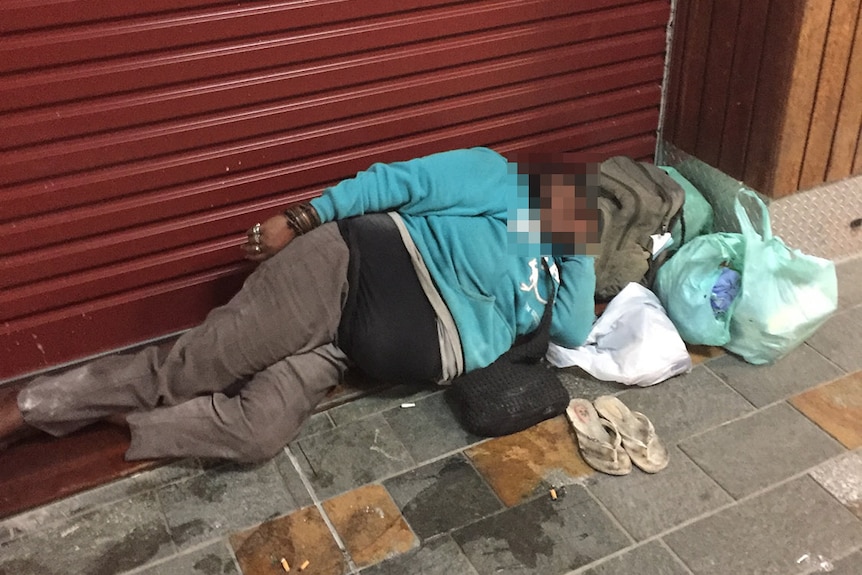 Homeless woman lies in street in Cairns CBD