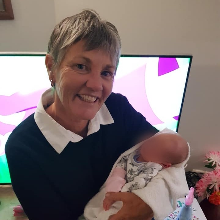 A woman cradles a baby.