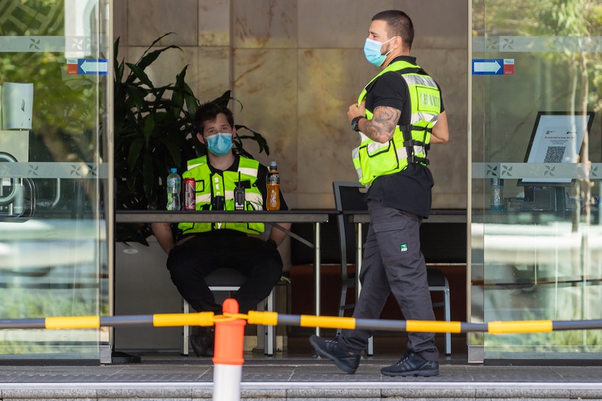 Two security guards stand in the lobby of a Perth quarantine hotel.