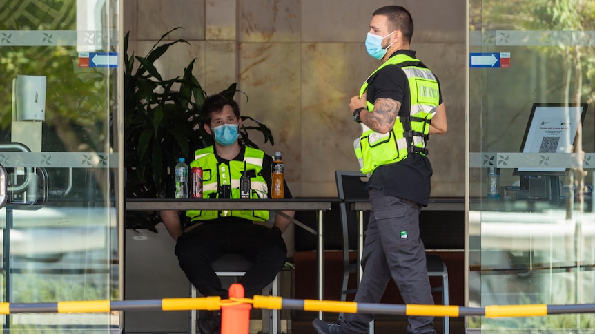 Two security guards stand in the lobby of a Perth quarantine hotel.