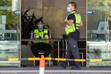 Two security guards stand in the lobby of a Perth quarantine hotel.