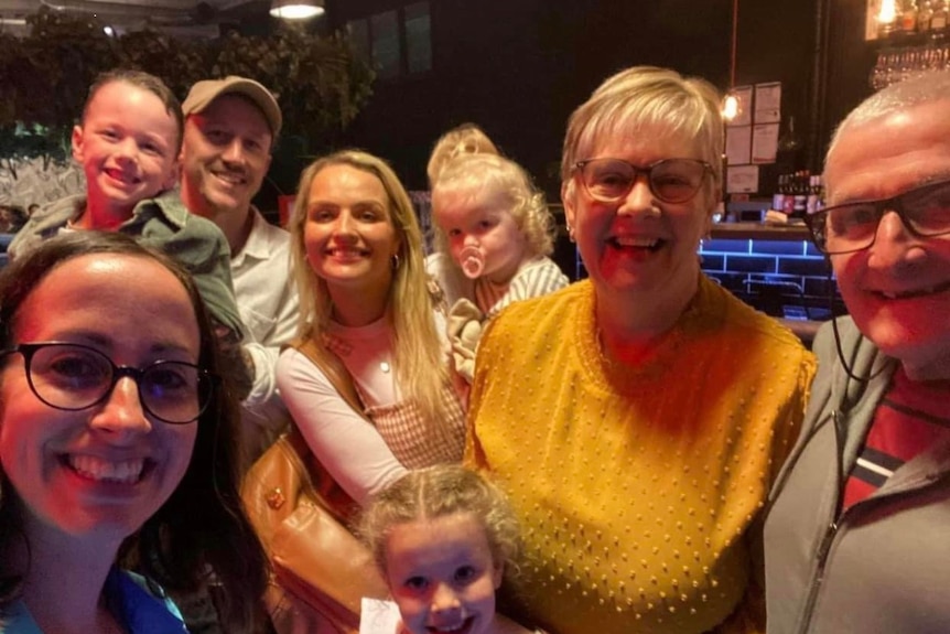 A selfie of a group of five adults and three children.