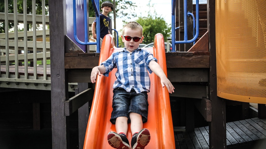 Oden Goudie coming down the slide wearing his red tinted glasses.