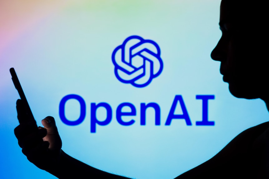 A close up image of someone using a phone in front of an OpenAI logo. 