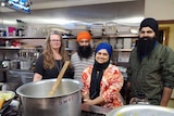 Sikh volunteers in kitchen with a giant pot