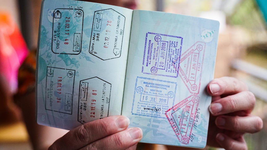 Hands holding a stamped passport.