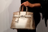A white and brown crocodile leather handbag.